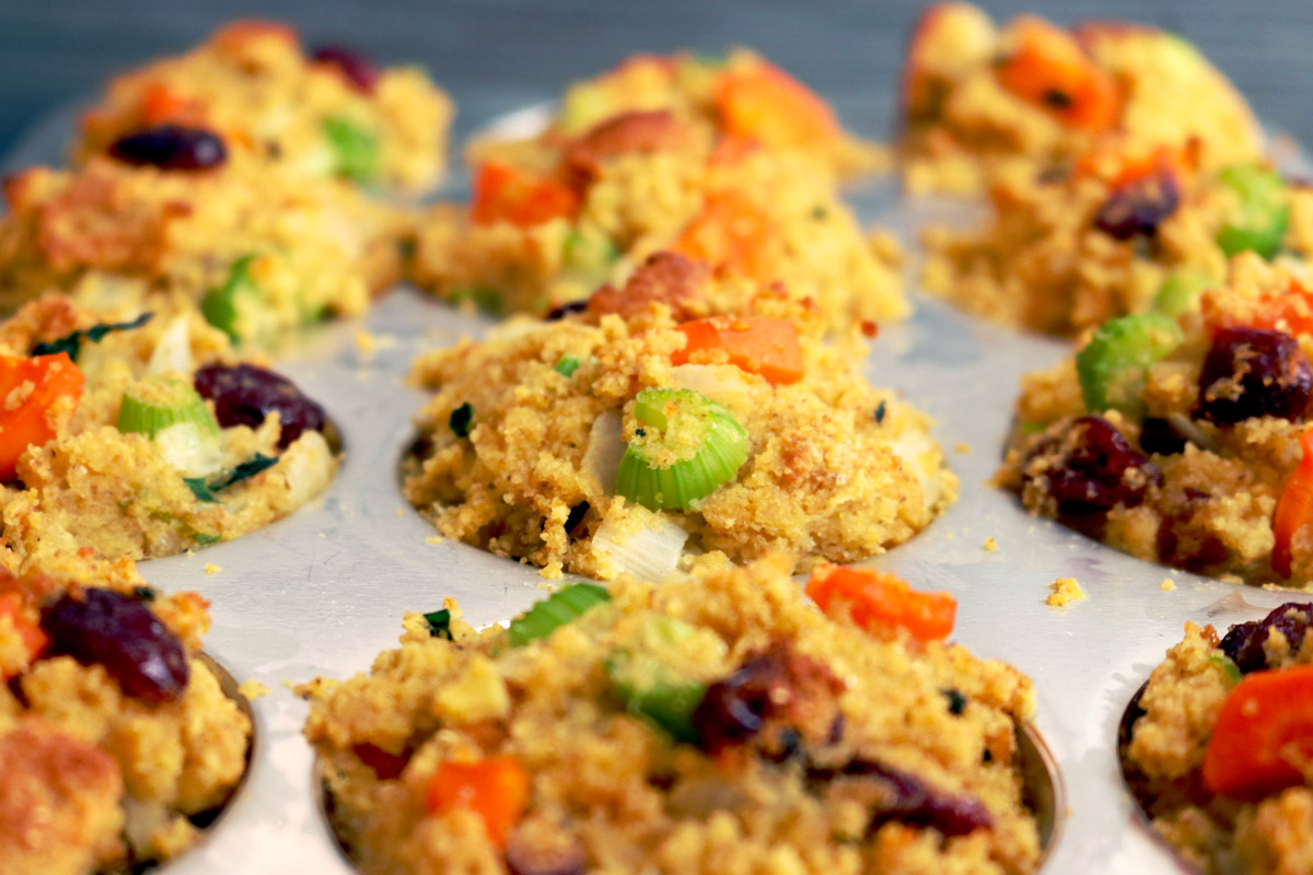 A muffin baking pan filled with cornbread stuffing mix.
