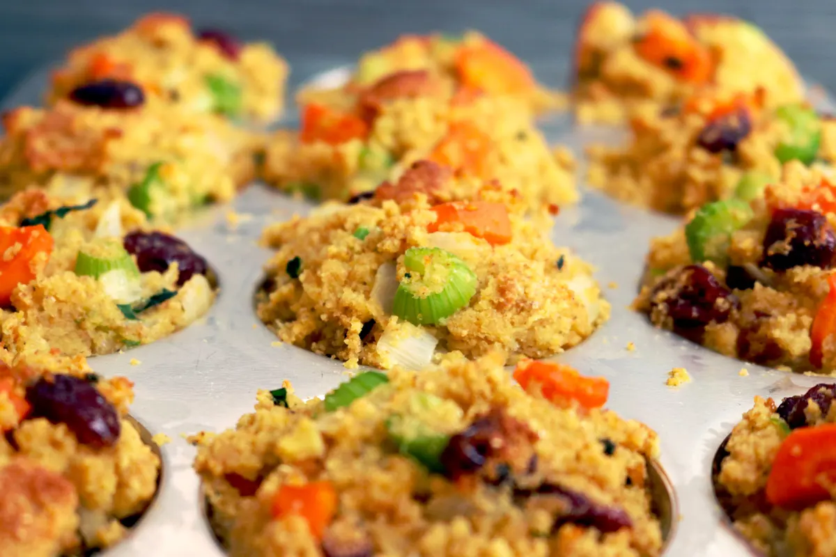 A muffin baking pan filled with cornbread stuffing mix.
