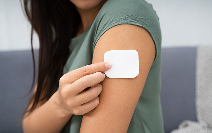 Woman putting on a nicotine patch.