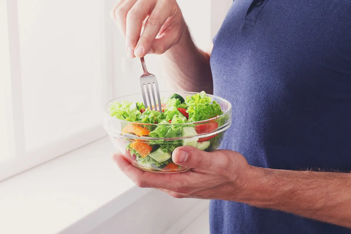 A person eating a healthy salad.