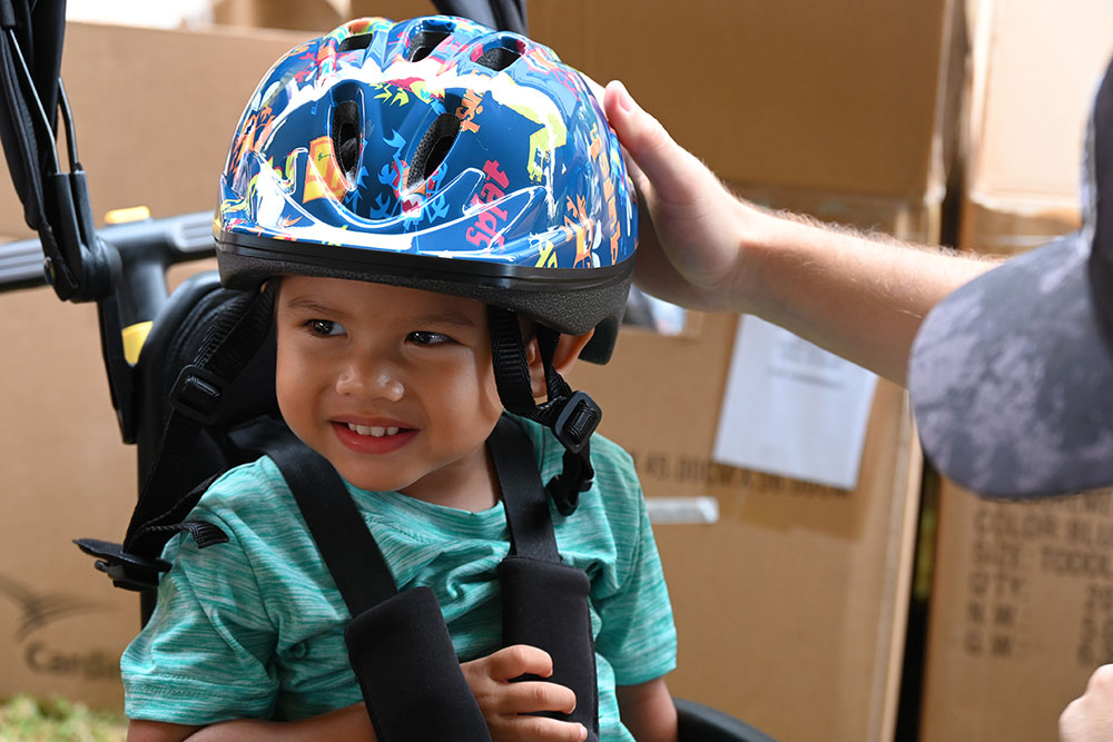 Young child getting fitted for a bike helmet.