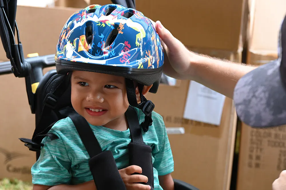 Young child getting fitted for a bike helmet.
