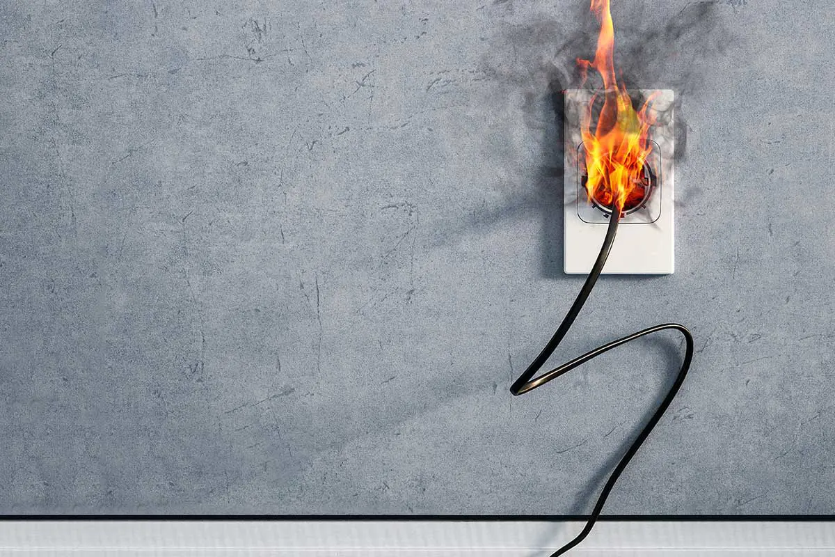 Fire and smoke on electric wire plug in electrical outlet.