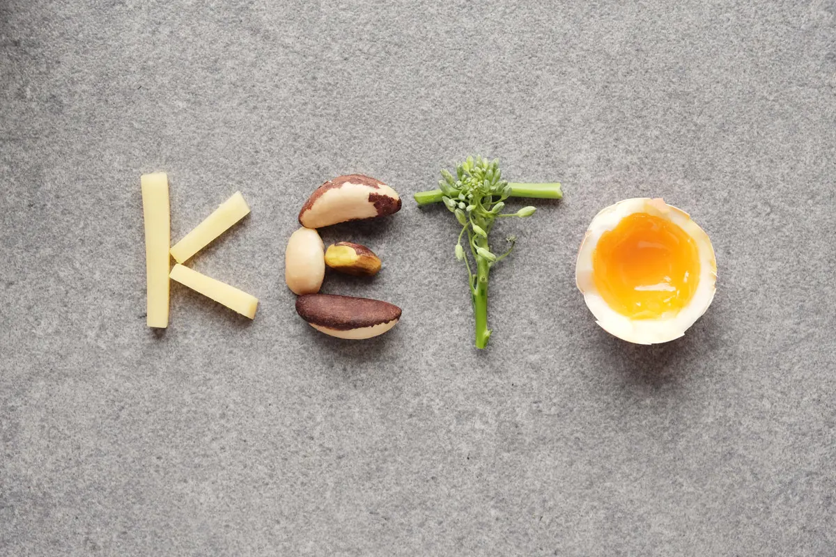 Cheese, nuts, broccoli and a soft-boiled egg spell out the word "KETO"
