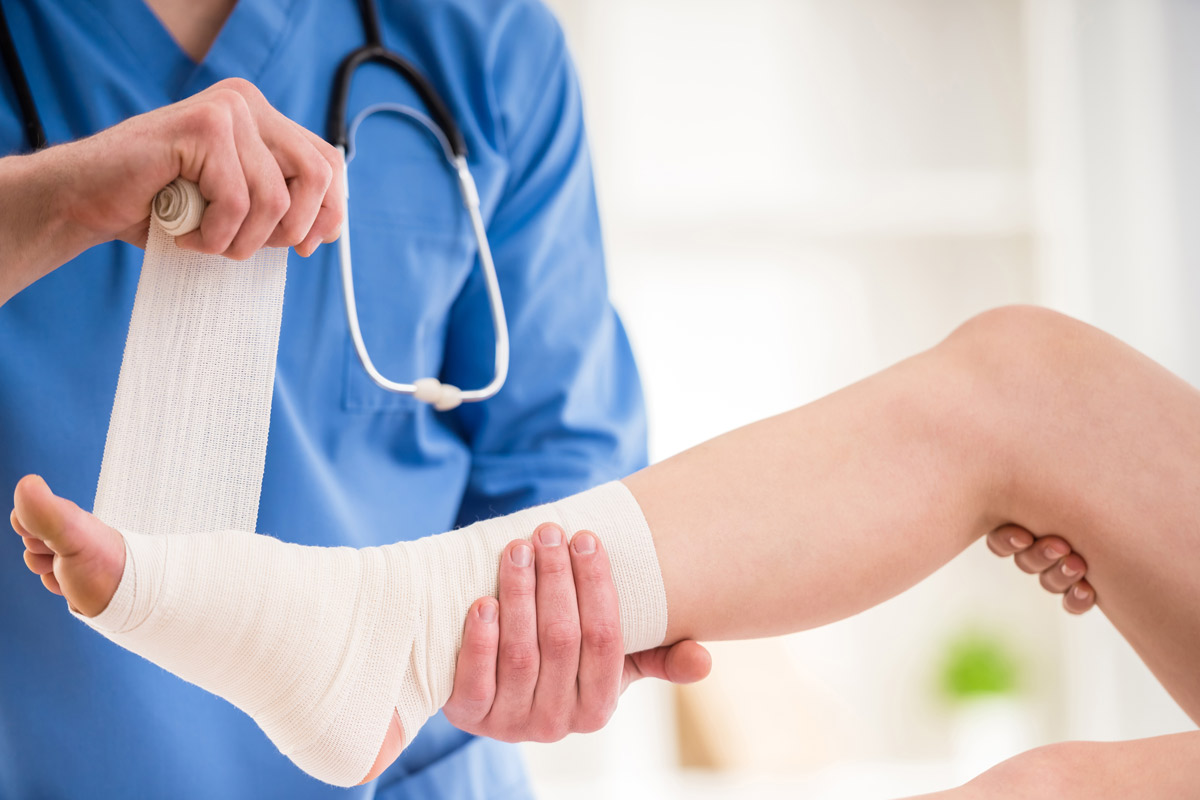 A foot getting wrapped by doctor.