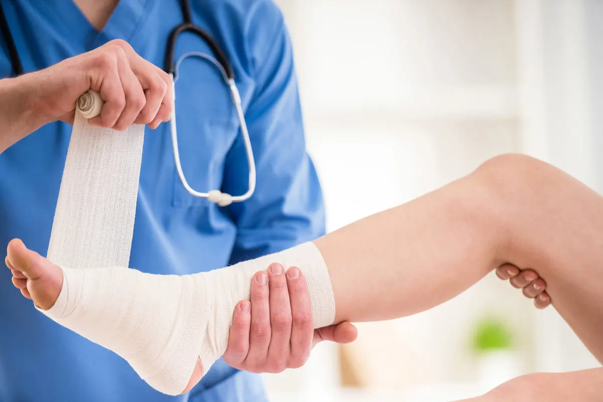A foot getting wrapped by doctor.