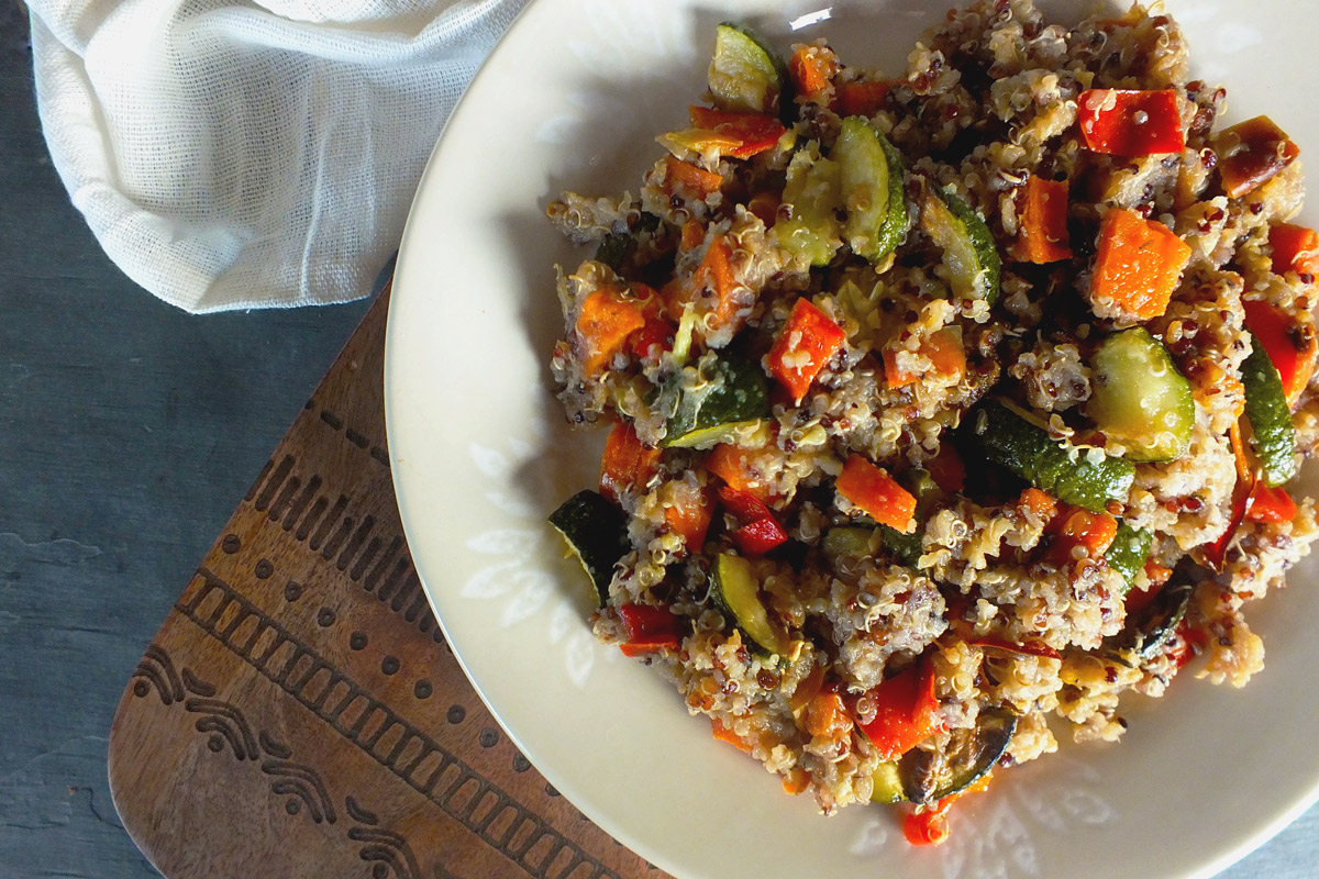 A colorfiul array of vegetables and quinoa sit on a white plate.