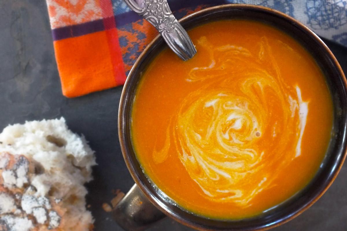 Orange soup with a swirl of coconut milk. 