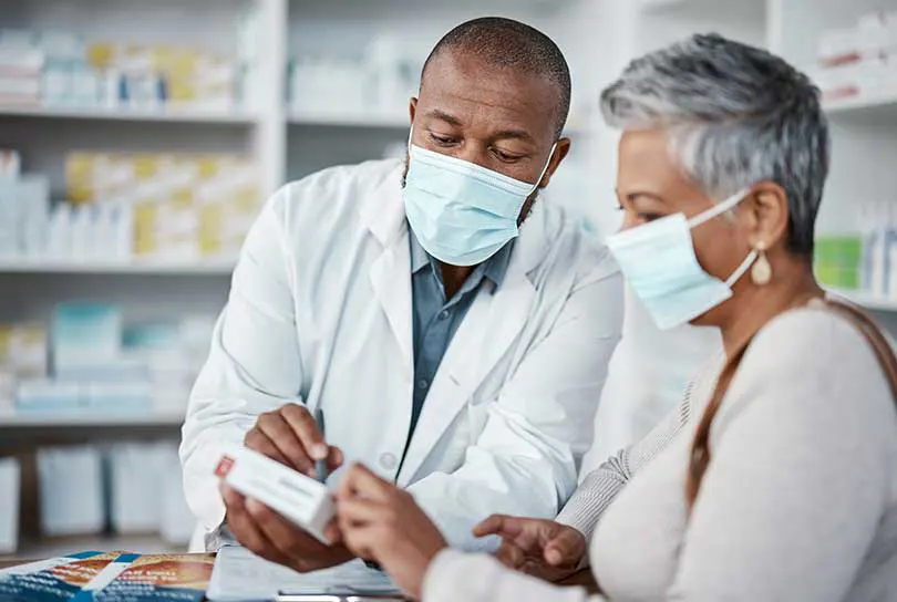 Stock photo of pharmacist consulting with patient