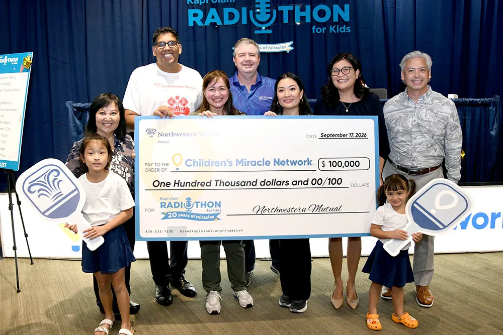 Large group shot of corporate leaders with a giant check for $100,000.