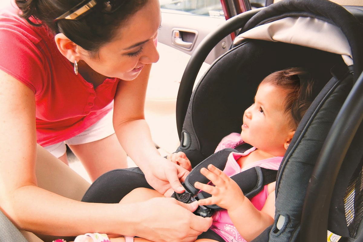 A woman securing child safety seat.