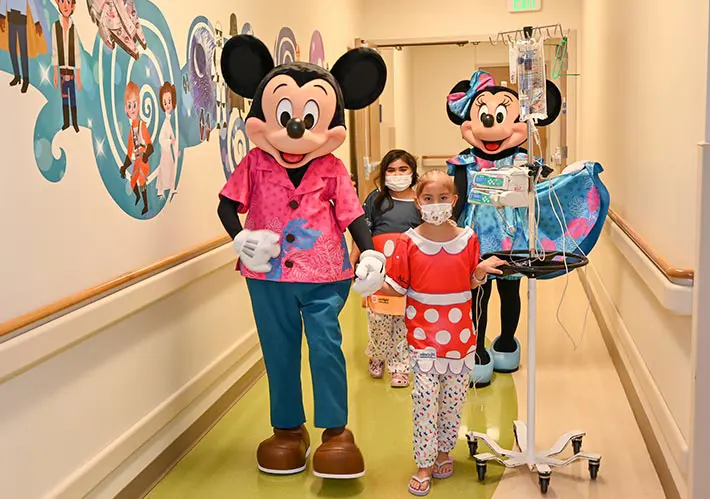 Disney character mascots posing with patients